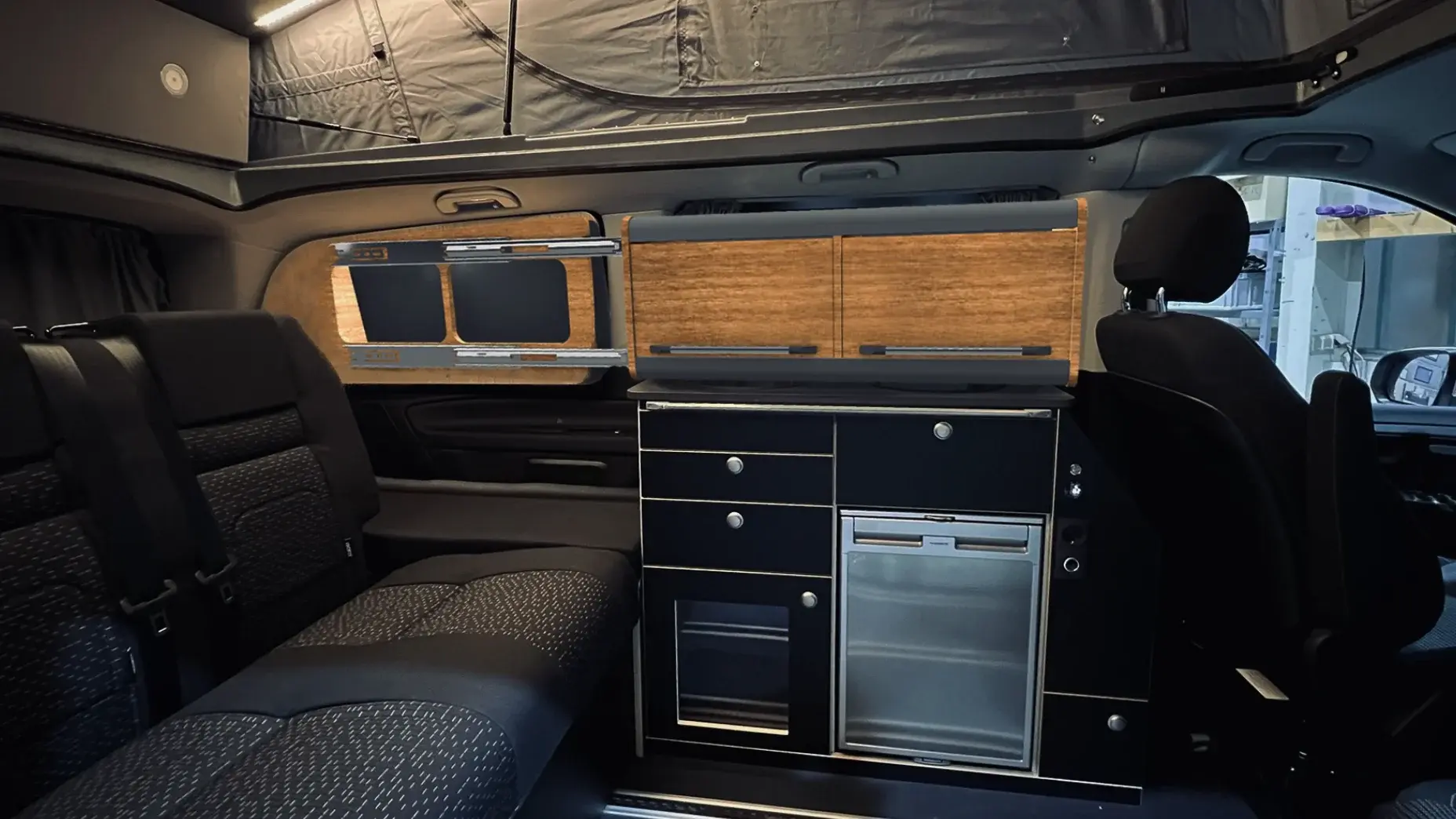 Verschiebbarer Hängeschrank im Fahrzeug – flexibles Stauraumkonzept im Innenraum eines Vans.