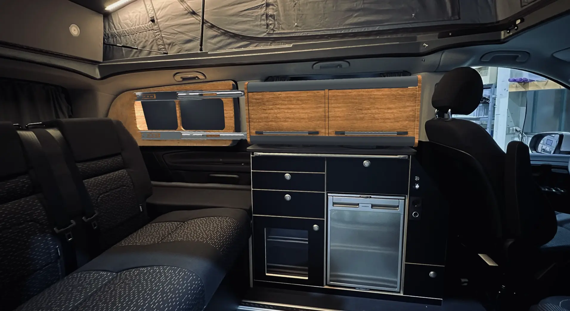 Verschiebbarer Hängeschrank im Fahrzeug – flexibles Stauraumkonzept im Innenraum eines Vans.